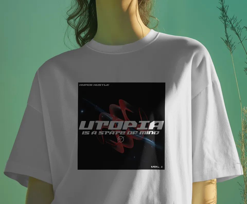 Model wearing the white Utopia oversized t-shirt against a green wall